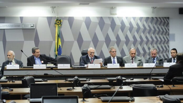 Pessoas em fila em um espaço coberto, aguardando atendimento em estandes do programa governamental em Abaetetuba.