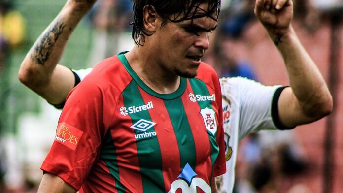 Jogadores de futebol de ABC e Sport disputam a bola no gramado do estádio Frasqueirão durante partida oficial.