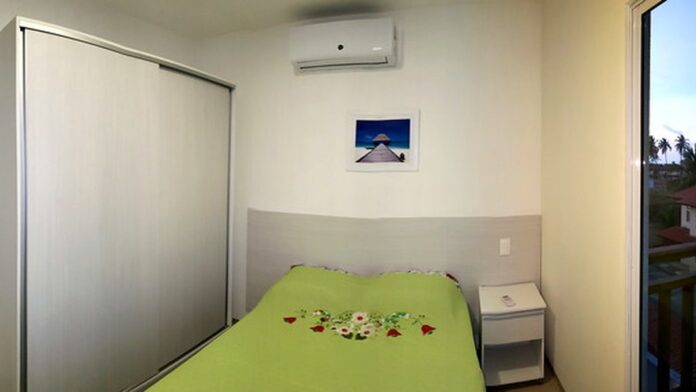 acr-na-tv-como-desativar-o-rastreamento-e-proteger Mãos segurando um controle remoto de televisão apontado para uma tela com ícones de configurações de privacidade abertos.