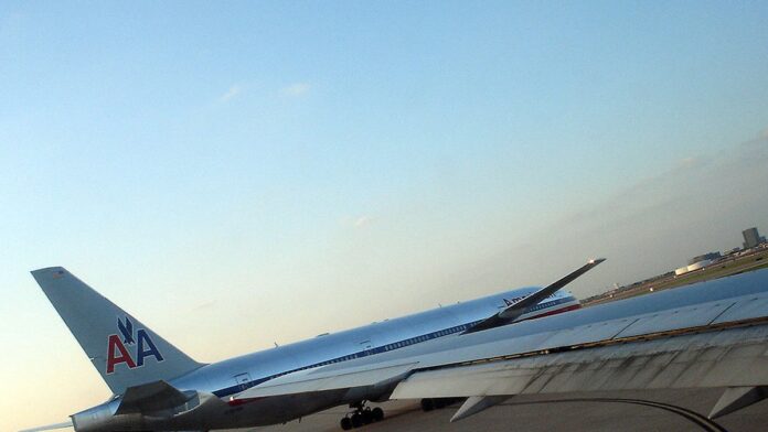 Agentes da TSA em fila de controle de segurança em aeroporto movimentado dos EUA.