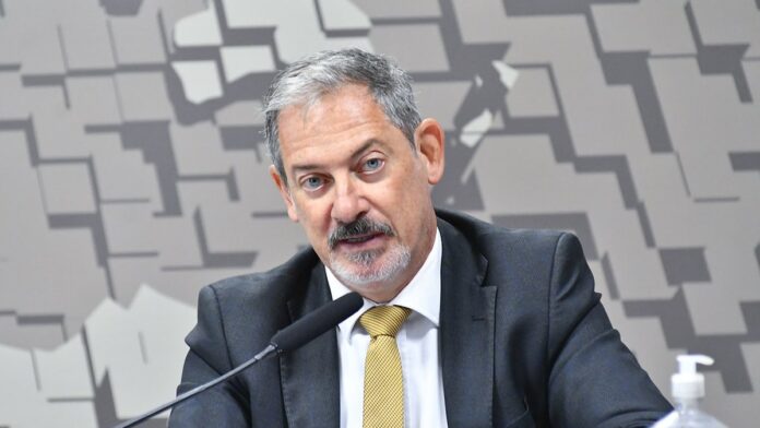 amazon-interrompe-servi-os-no-bahrein-ap-s-ativida Drone comercial sobrevoando uma área industrial ensolarada com contêineres e galpões ao fundo.