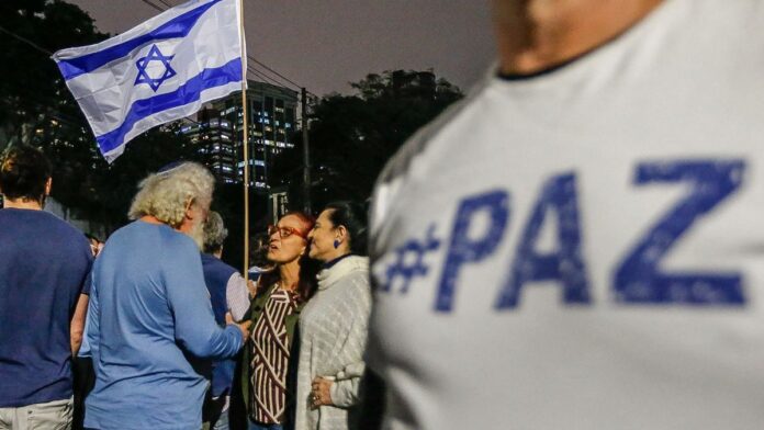 Foto de arquivo com representantes da Conib em conferência de imprensa, com logo da instituição ao fundo.