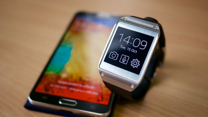 Apple Watch SE de cor clara em foco, exibindo interface de apps em fundo desfocado de ambiente moderno.