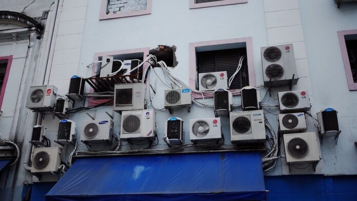 Close em um controle remoto de ar-condicionado branco, destacando o botão de função de autolimpeza em destaque.