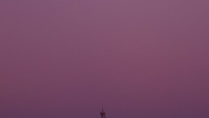 Quatro astronautas da NASA posam juntos em traje espacial para a missão Artemis 2, com o fundo da bandeira americana.