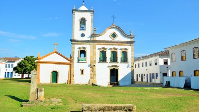 Operários trabalham em canteiro de obras de um novo centro de treinamento com gramado ao fundo na Cidade do Galo.