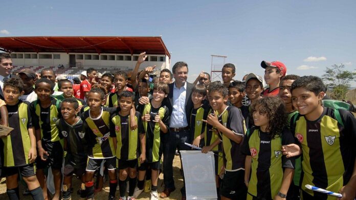 Jogadoras de futebol com uniformes de Atlético-MG e São Paulo disputam a bola no gramado durante partida oficial.