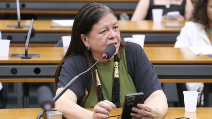 autoriza-o-de-viagem-de-menores-ao-exterior-ter-va Passaporte brasileiro aberto sobre uma mesa de madeira, ao lado de uma caneta e documentos de viagem.