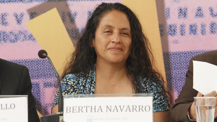 Bertha Navarro, mulher madura, sorrindo, em evento de cinema, com troféu.