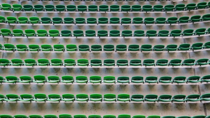 Oliver Sykes cantando em palco iluminado por luzes neon azuis e roxas durante show da banda Bring Me The Horizon.