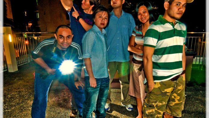 Os sete integrantes do BTS posam juntos em um cenário iluminado, vestindo figurinos elegantes e modernos.