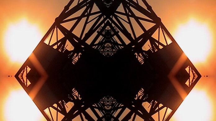 Ca7riel e Paco Amoroso posam juntos em palco iluminado, com figurinos estilizados e microfones em mãos.