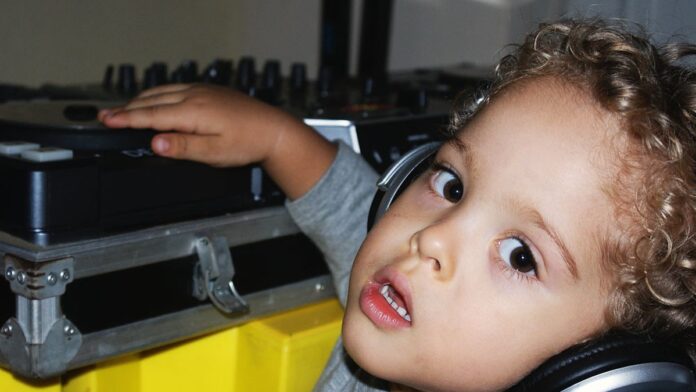 Duas caixas de som inteligentes da Denon, de formato cilíndrico e acabamento em tecido cinza, sobre uma superfície clara.