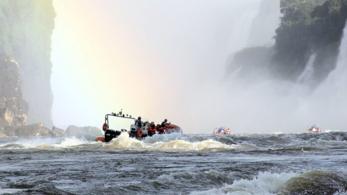 Profissional de saúde aplicando vacina no braço de uma pessoa sentada em uma unidade básica de saúde em Curitiba.