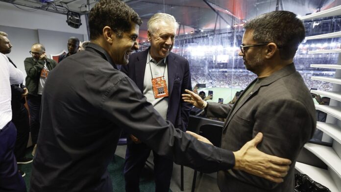 Carlo Ancelotti gesticula durante entrevista coletiva, com expressão pensativa e fundo desfocado.