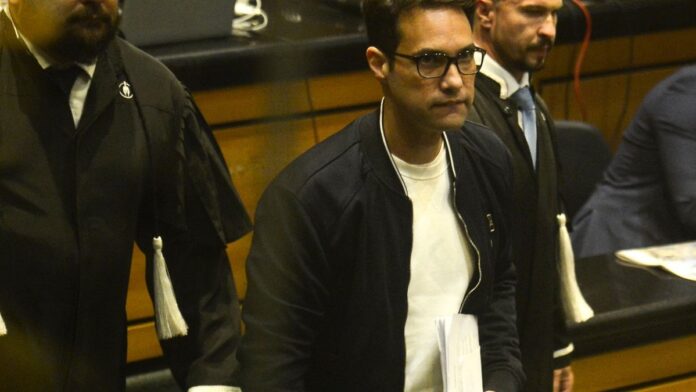 Fachada do Tribunal do Júri do Rio de Janeiro com movimento de pessoas e profissionais de imprensa na entrada.