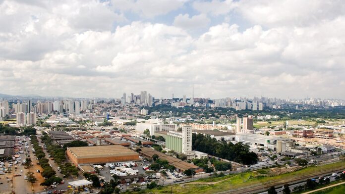 Fachada de um pavilhão da Ceasa com portões fechados e ausência de movimento em um dia ensolarado.