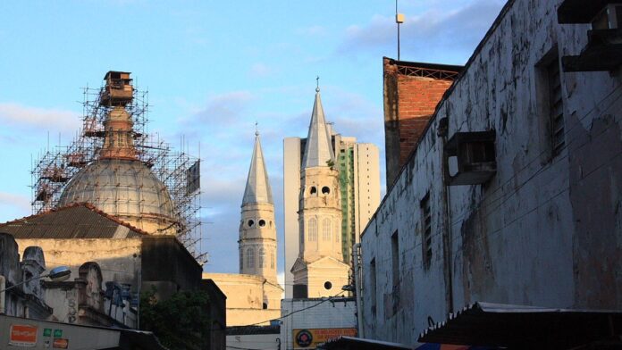 Profissional da saúde sorridente atende criança em sala colorida e lúdica do Centro de Autismo.