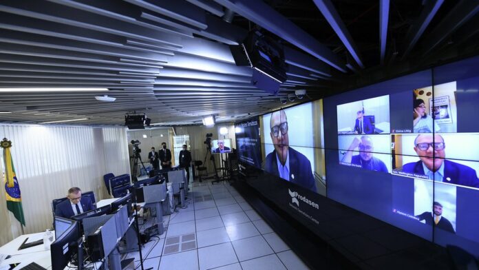 Pessoa ao volante de um carro, focada na manobra durante um exame de direção, com câmbio automático em destaque.