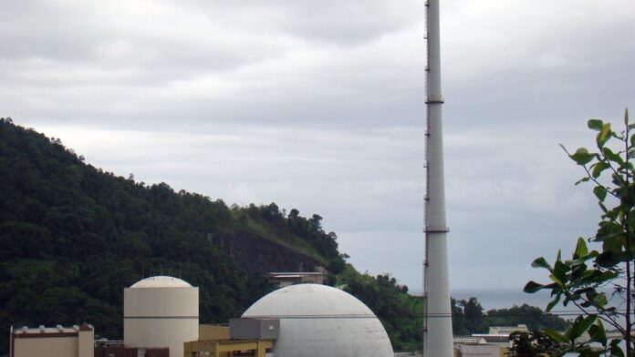 Smartphone apoiado em painel de carro em uma rodovia, exibindo sinal de rede 5G na tela durante viagem.