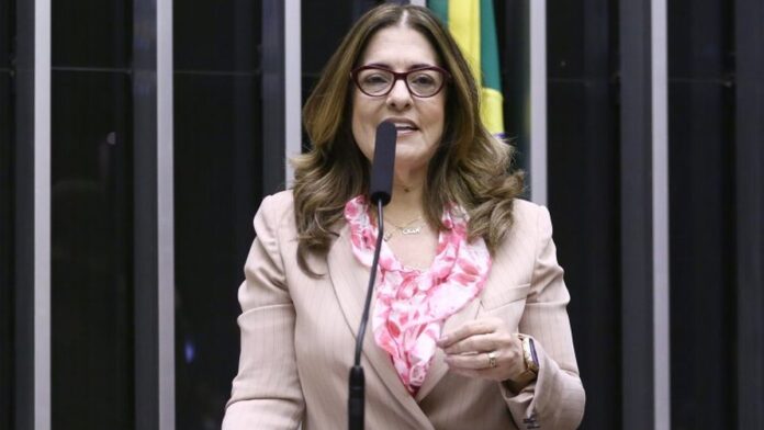 Idoso com pulseira de monitoramento digital no pulso, em ambiente doméstico bem iluminado.