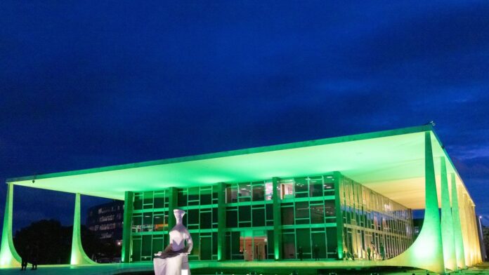 Ministro André Mendonça sentado à mesa em sessão do STF, com semblante sério, durante análise de processo jurídico.