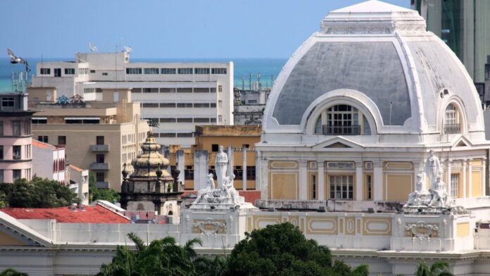 Fachada do Tribunal de Justiça do Rio de Janeiro com movimento de pessoas entrando e saindo do prédio.