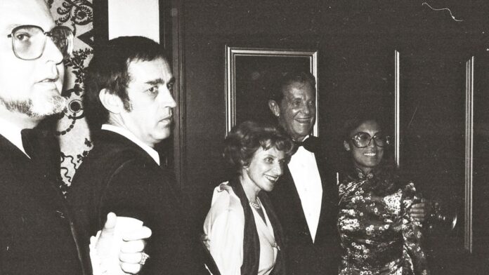 Close em um wafer de silício com circuitos microprocessadores detalhados iluminado por luzes azuis em laboratório.