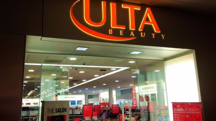 Vários produtos de beleza coloridos dispostos sobre uma mesa com um ícone de etiqueta de desconto em destaque.