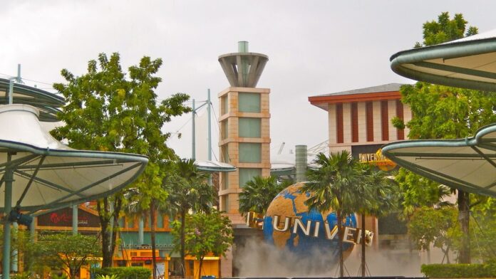 Golfinho salta sobre a água em uma piscina rasa de resort, cercado por estruturas metálicas de contenção.