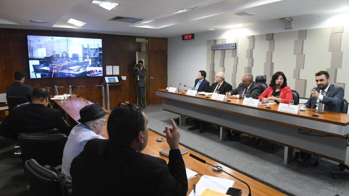 Pilha de resíduos mistos e diversos descartados em uma esteira de separação dentro de uma cooperativa de reciclagem.
