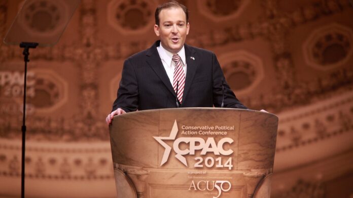 Caminhão pesado estacionado em área industrial, visto de perfil, com motor ligado e fumaça saindo do escapamento.