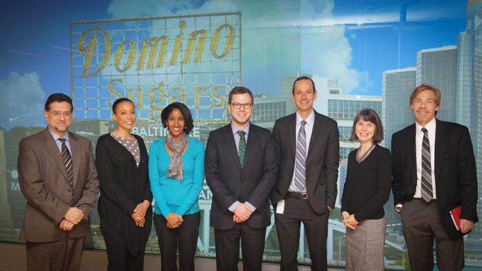 Roteador sem fio de cor branca com antenas externas posicionado sobre uma superfície escura.