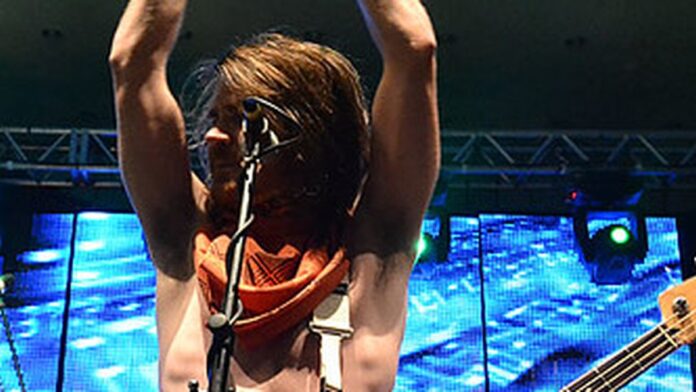 Dois helicópteros militares sobrevoam uma grande propriedade residencial.