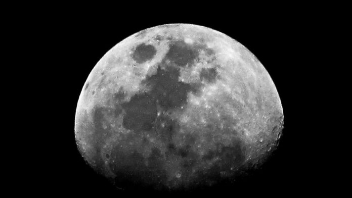 Lua crescente iluminada no céu noturno escuro, vista em detalhes contra o fundo do espaço.