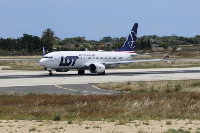 Aeronave da LOT Polish Airlines se preparando para decolar em um dia ensolarado.