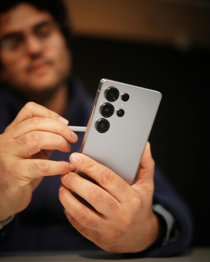 Close de uma pessoa usando uma caneta com um smartphone moderno, aumentando a precisão e a funcionalidade.