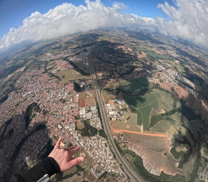 Uma vista aérea deslumbrante que mostra uma mistura de paisagens urbanas e rurais sob um céu nublado.