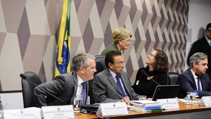fernando-morais-lan-a-biografia-lula-volume-2-sobr Fernando Morais sorri ao lado de Lula, que segura o exemplar do segundo volume de sua biografia em evento de lançamento.