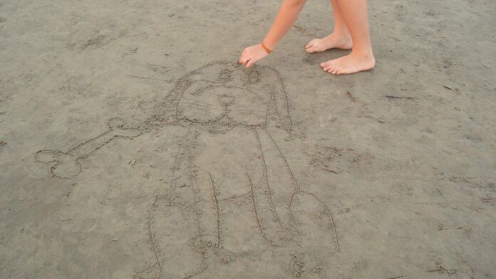 Músico do Red Hot Chili Peppers diante de lápide em cemitério arborizado.