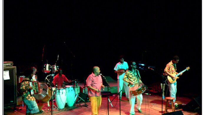 Mapa-múndi com símbolos de alerta sobre Oriente Médio e gráficos econômicos em queda.