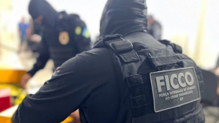 Agentes em coletes à prova de balas inspecionam grandes fardos de drogas apreendidas.