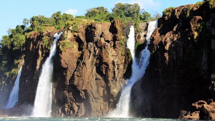 Grupo de profissionais em trajes formais posando para foto em um auditório moderno durante evento internacional.