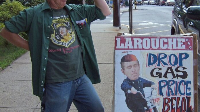 Placa de posto de gasolina nos EUA exibindo preços elevados em painel digital luminoso sob céu claro.