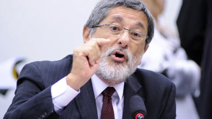 Plataforma de petróleo em mar aberto sob céu alaranjado, simbolizando exploração e vulnerabilidade energética.