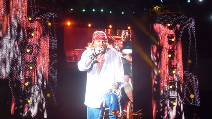 Axl Rose e Slash apresentam-se em um palco iluminado por luzes coloridas durante show da nova turnê do Guns N' Roses.