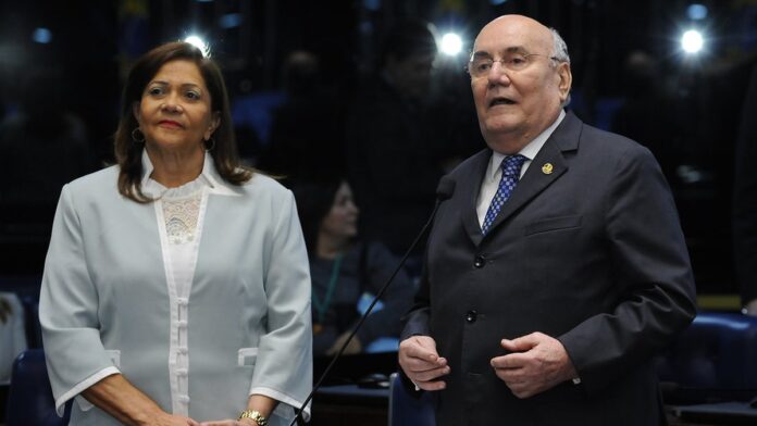 Helder Barbalho entrega documentos oficiais a um conselheiro em mesa de reunião no Tribunal de Contas do Pará.