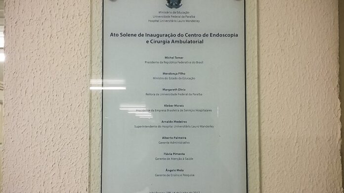 Equipe médica de uniforme em centro cirúrgico hospitalar, focada em procedimento cirúrgico.