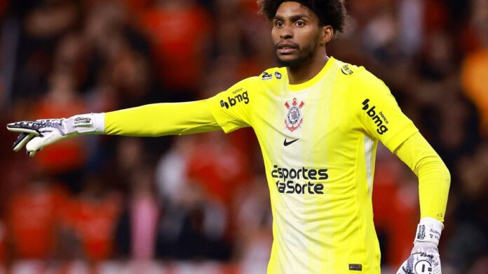 Goleiro comemorando com as mãos erguidas em campo