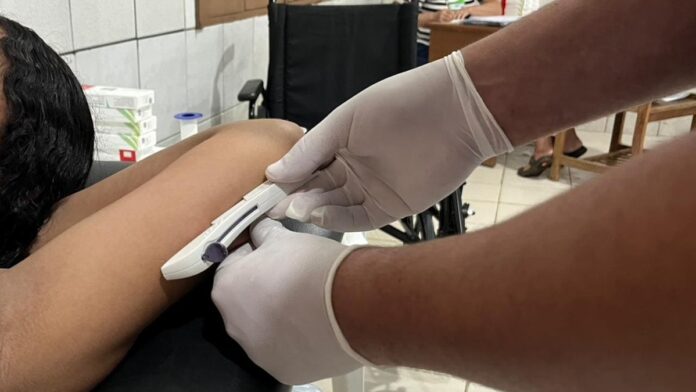 Adolescente em consultório médico recebendo implante contraceptivo no braço aplicado por profissional de saúde.